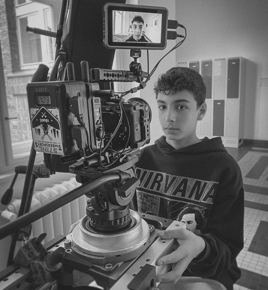 a boy sitting in front of a camera